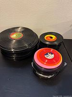 Two separate piles of unsleeved LPs and 45s on tabletop