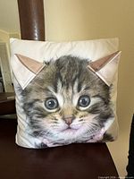 Front of pillow showing kitten face and fabric ears