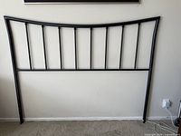Full front view of black metal headboard against wall