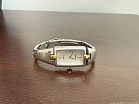 Front three-quarter view of watch showing dial, case and part of bracelet