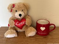 Teddy bear and mug on wooden surface front view