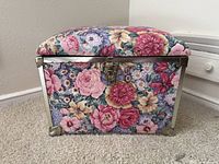 Front view of floral fabric trunk chest showing latch and metal corners