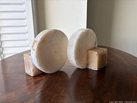 Front view of both marble bookends showing circular faces and square bases