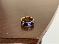 Angle view of blue enamel band ring on table