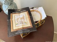 Overview of sewing basket with cross-stitch kit inside