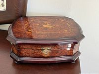 Closed jewelry box showing burl wood finish and latch