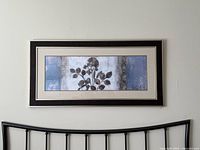 Full view of framed art on wall over headboard