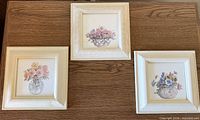 All three framed floral watercolors displayed on table