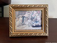 Front view of ornate gold frame displaying kitten print