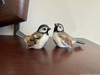 Front view of both sparrow figurines on tabletop