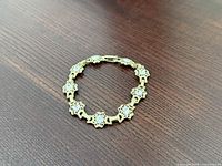 Full view of goldtone bracelet on wooden surface