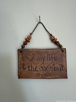 Front view of ceramic plaque showing phrase and beads