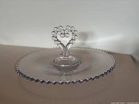 Top view of clear glass Candlewick sandwich tray showing beaded rim and central handle