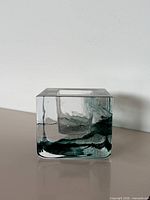 Front view of square crystal votive with green swirl