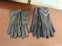 Two pairs of gloves side by side, top views