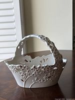Overall view of Lenox porcelain cherry blossom basket showing handle, pierced rim, and raised floral design