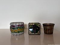 Front view of three glass mosaic candle holders