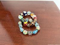 Both stretch bracelets side by side on wood surface