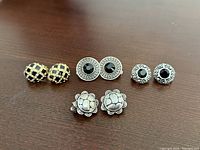 All four earring pairs arranged on wood surface