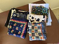 Group of folded scarves showing range of patterns and colours