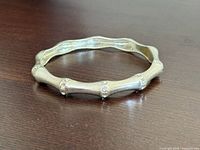 Full view of bamboo-style silvertone bangle on tabletop
