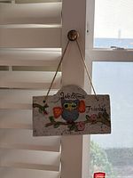 Front view of owl welcome plaque hanging, shows full design and text