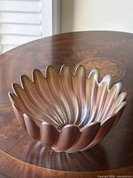 Top view of fluted iridescent gold glass bowl on wood surface