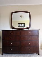 Front view of dresser showing eight drawers and matching mirror