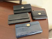 Top view of all four wallets on wooden surface