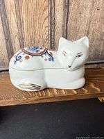 Profile view of porcelain fox trinket box with painted Chinoiserie design