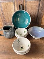 Group shot of pitcher, four small bowls, teal bowl, blue bowl