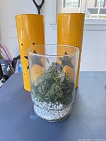 Front view showing glass vase with moss and both yellow metal lanterns