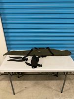 Full view of olive green soft rifle case on table