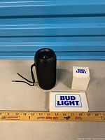 All main items: black cylindrical speaker, two Bud Light boxes