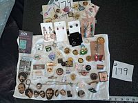 overall view of pins, earrings, necklaces and charms spread on towel