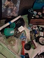 Group shot of posters, wand, cup, candle holder, buttons, bags