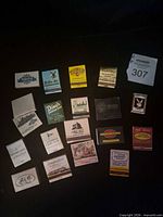 Top-down view of full assortment of matchbooks and metal cover