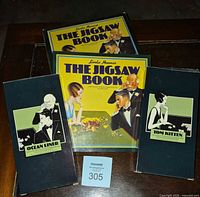 Front view of both sealed puzzle boxes and two copies of The Jigsaw Book showing labels 'Ocean Liner' and 'Tom Kitten'