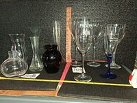 Group of vases and stemware with ruler and tape for scale
