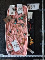 Full tray view showing mixed earrings, bracelets, pendants, brooches and charms