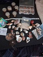 overview of lot showing shells, votives, storage box, pebbles, jewelry pieces