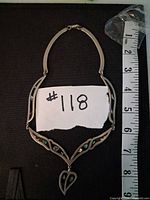 Full view of necklace laid flat with measuring tape