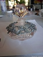 Front view of pink glass perfume bottle with pewter rose overlay and heart stopper