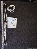 Necklace and bracelet laid out beside ruler for scale