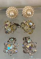 Front view showing both earring pairs: faux pearl screw-backs at top, aurora borealis crystal clip-ons below