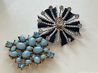 Both brooches side by side showing overall designs