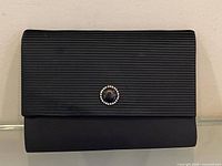 Front view showing pleated flap and cabochon with rhinestones