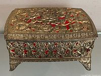 Top view showing floral brass filigree and red velvet underneath