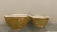 Two ceramic mixing bowls side by side showing exterior pattern and size difference