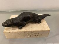 Bronze otter sculpture on stone base top view
